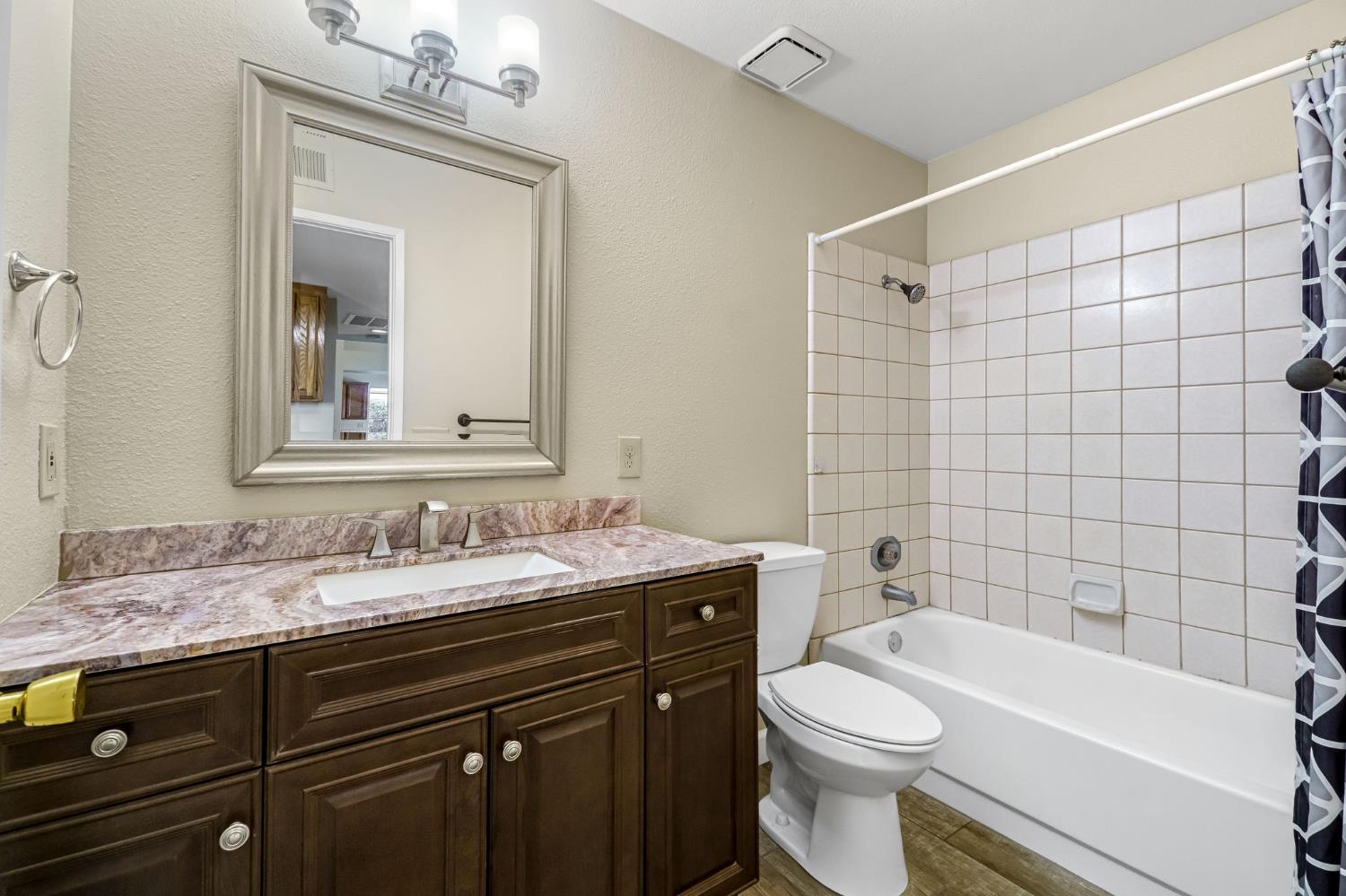 3837 North State Street Fresno, CA 93722 - Photo 25 of 33 a bathroom with a sink a toilet and shower