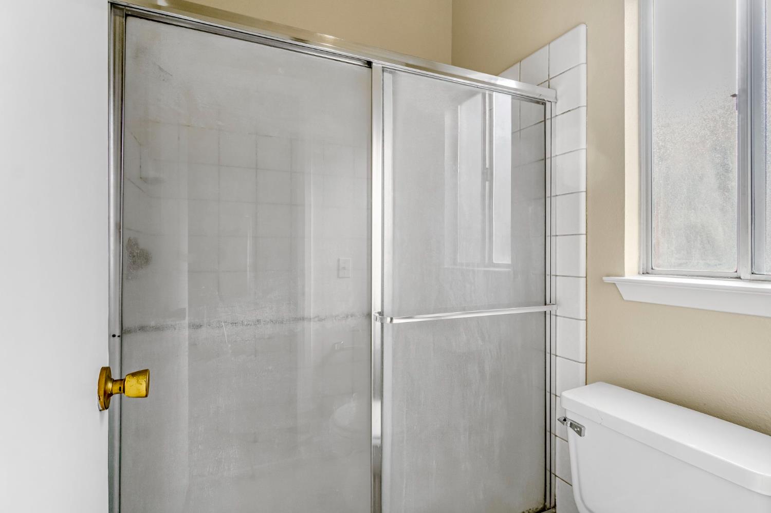 3837 North State Street Fresno, CA 93722 - Photo 29 of 33 a bathroom with a shower and a toilet