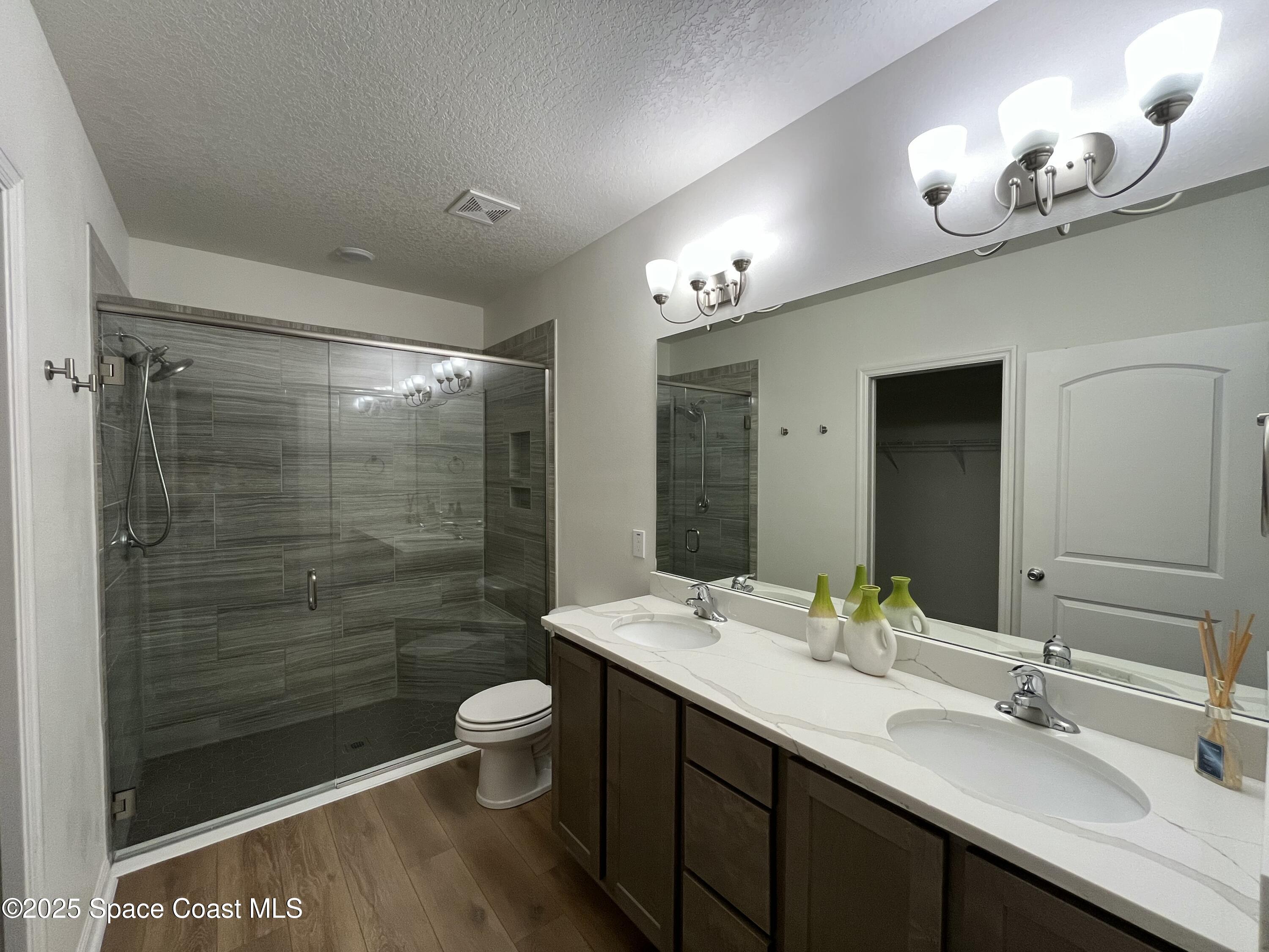 95 Montecito Drive Satellite Beach, FL 32937 - Photo 4 of 20 a bathroom with a double vanity sink toilet and a mirror