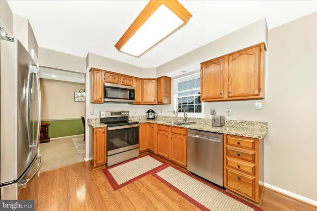 a kitchen with stainless steel appliances granite countertop a stove a sink and a refrigerator