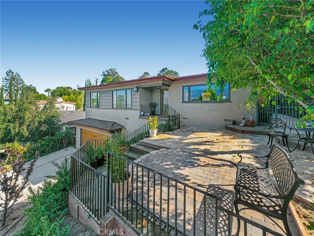 a view of a house with backyard and sitting area