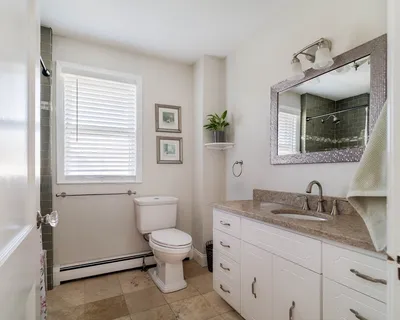 a bathroom with a granite countertop toilet sink and mirror