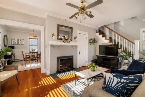 a living room with furniture a flat screen tv and a fireplace