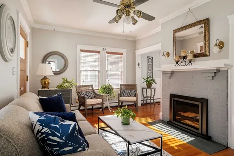 a living room with furniture a fireplace and a flat screen tv
