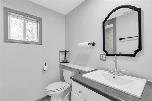 a bathroom with a toilet sink and mirror