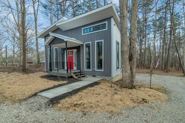 a view of a brick house with large windows and large tree