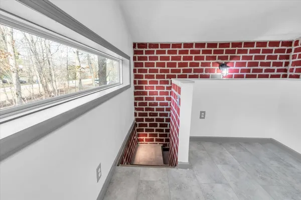 a bathroom with a sink a mirror a toilet and a window