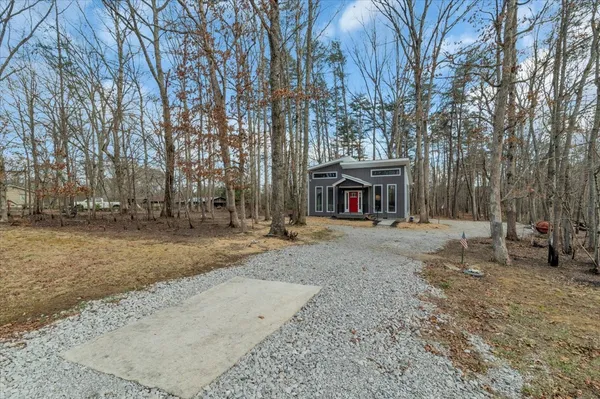 a view of a house with large trees and covered with snow