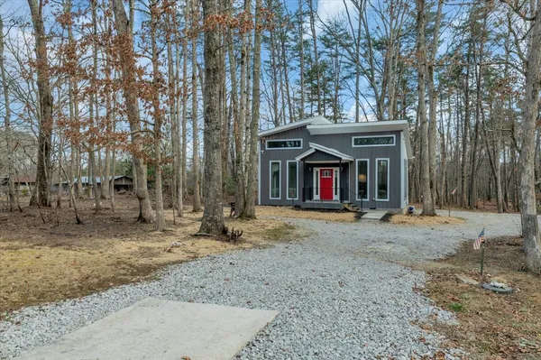 a view of brick house with large windows and a large tree