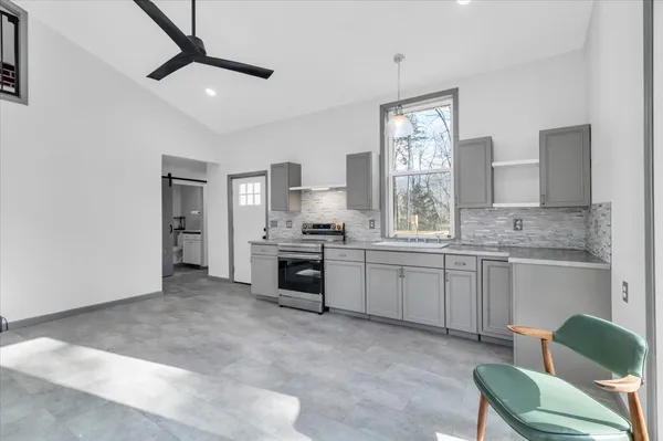 a kitchen with granite countertop a sink cabinets stainless steel appliances and a window