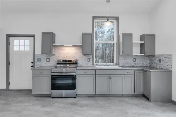 a kitchen with stainless steel appliances granite countertop a stove and white cabinets