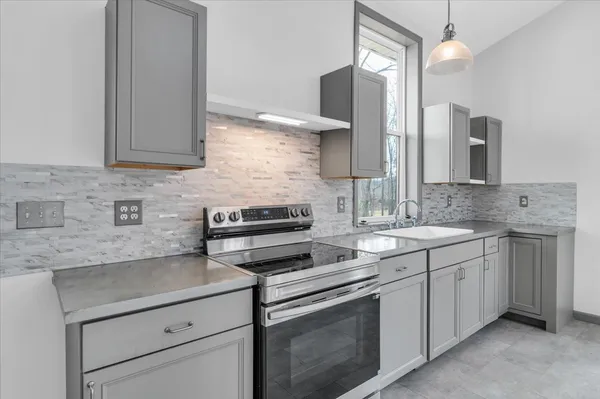 a kitchen with a sink stove and cabinets