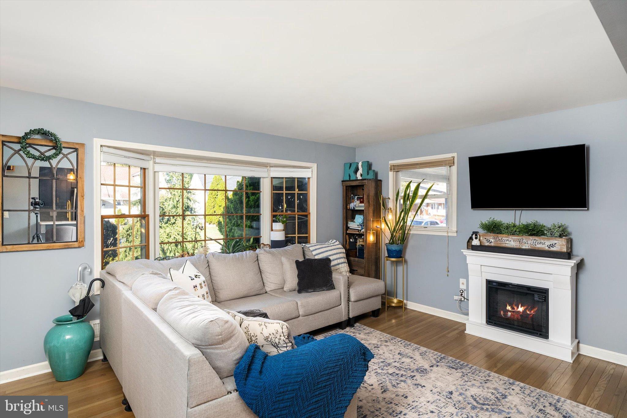 23 Beaumont Road Hamilton, NJ 08620 - Photo 9 of 45 a living room with furniture a flat screen tv and a fireplace