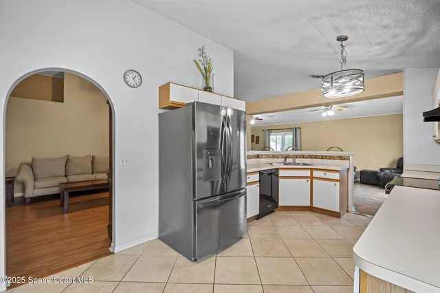 a kitchen with white cabinets and window