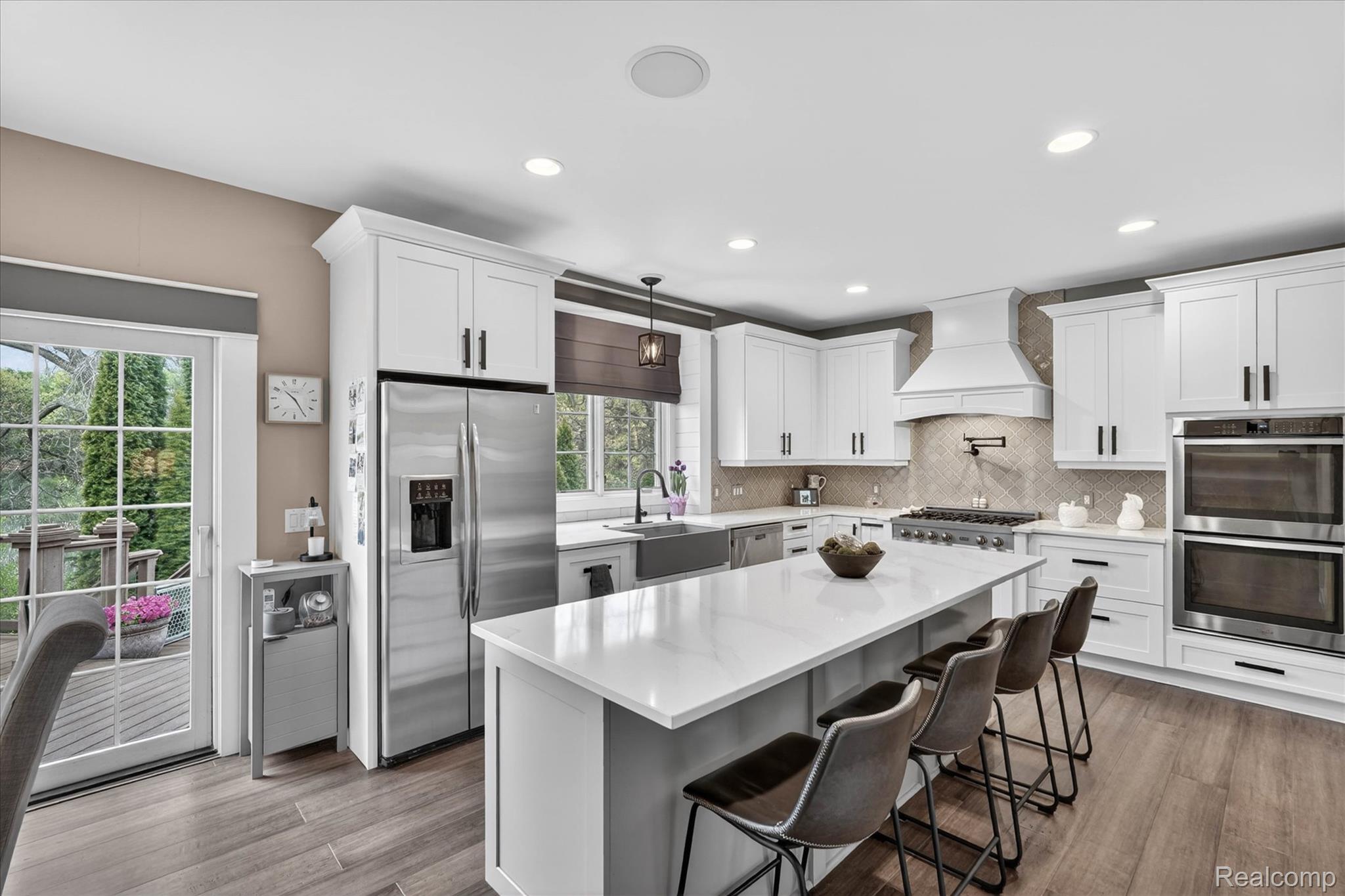 9074 Ridgefield Drive Brighton, MI 48114 - Photo 11 of 75 Kitchen featuring stainless steel appliances, pendant lighting, white cabinetry, and a kitchen bar