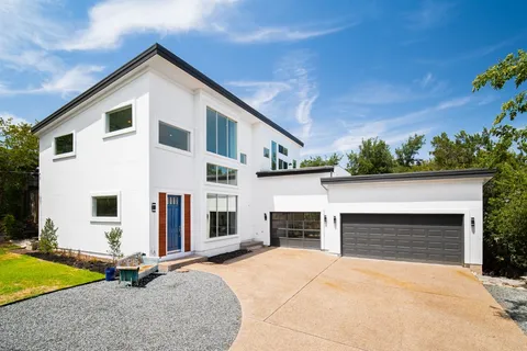 a view of house with yard and trees in the background