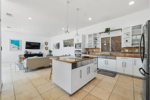 a living room with furniture and a view of kitchen