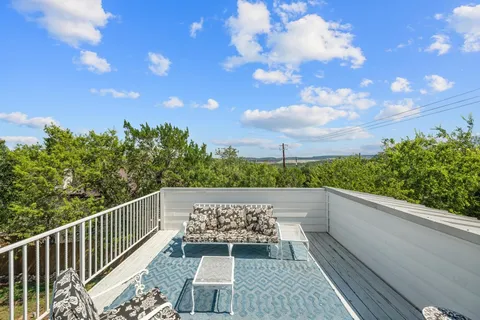 a view of balcony with wooden floor and fence