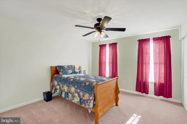 a bedroom with a bed dresser and a chandelier