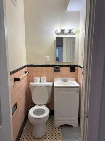 a bathroom with a toilet sink and mirror