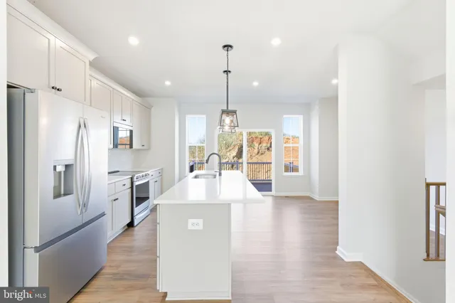 a kitchen with stainless steel appliances a refrigerator sink and cabinets