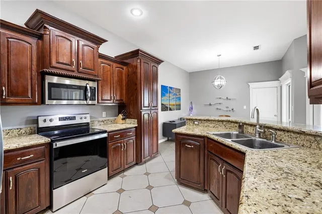 a kitchen with stainless steel appliances granite countertop a sink stove and cabinets