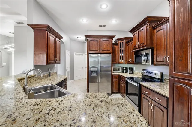 a kitchen with stainless steel appliances granite countertop a sink stove and refrigerator