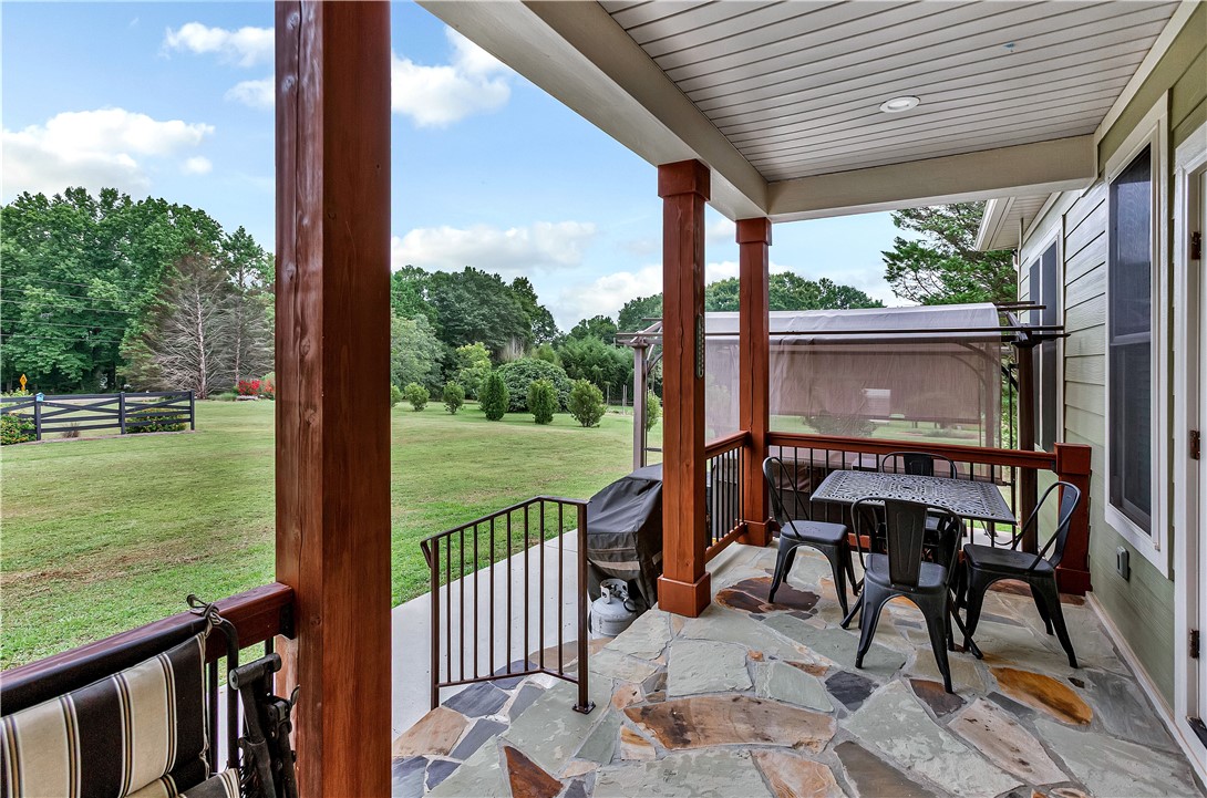 1204 Cherokee Road Townville, SC 29689 - Photo 34 of 44 An inviting stone patio unfolds to a wide, verdant lawn, ideal for tranquil outdoor enjoyment.