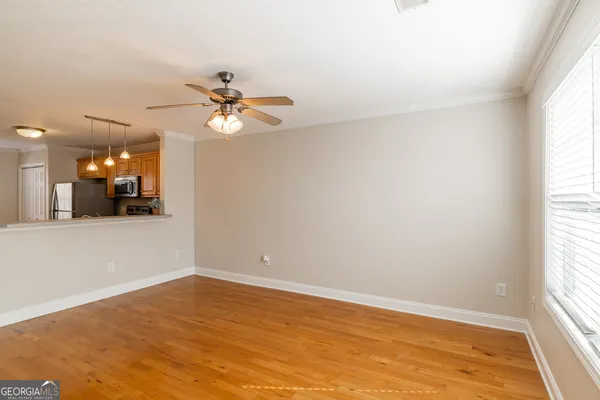 an empty room with a window and a ceiling fan
