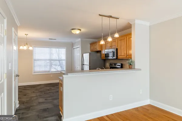 a view of a kitchen with wooden floor and a window