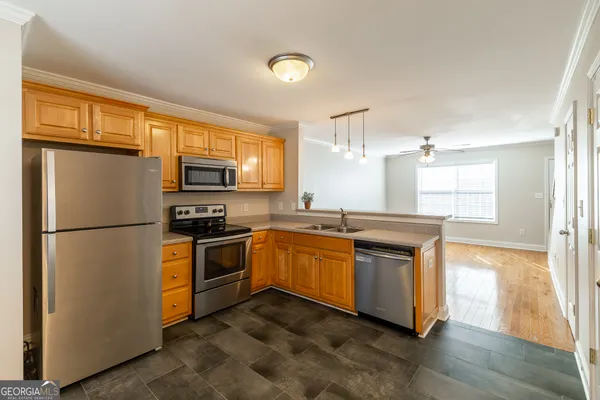 a kitchen with stainless steel appliances granite countertop a refrigerator a stove a sink and a microwave