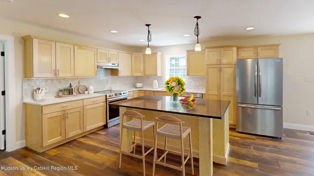 a kitchen with granite countertop a refrigerator a sink appliances and cabinets