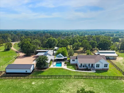 an aerial view of a house with a garden and lake view