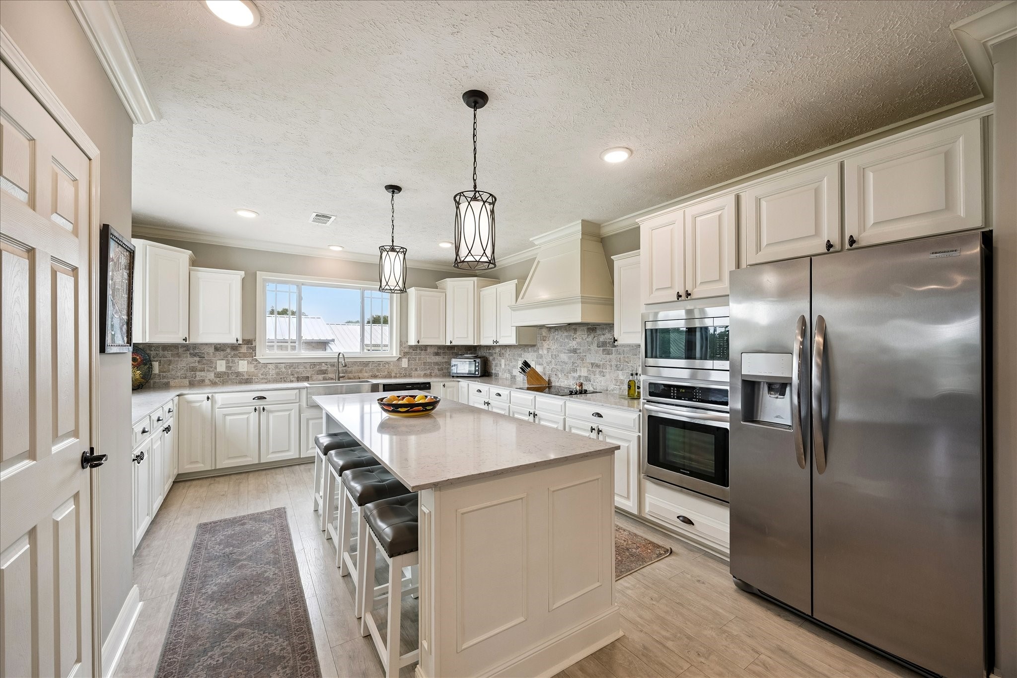 15946 Farm To Market Road 1094 Cat Spring, TX 78933 - Photo 14 of 50 a kitchen with white cabinets and stainless steel appliances