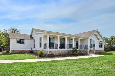 a front view of house with yard and green space