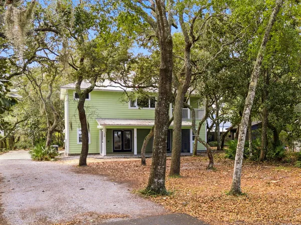 a front view of a house with a tree