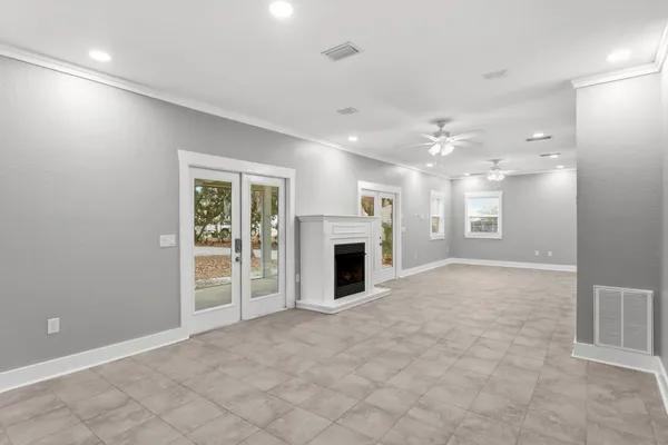 a view of a livingroom with a ceiling fan fireplace and a window