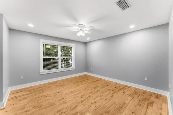 a view of a bedroom with a ceiling fan and a window