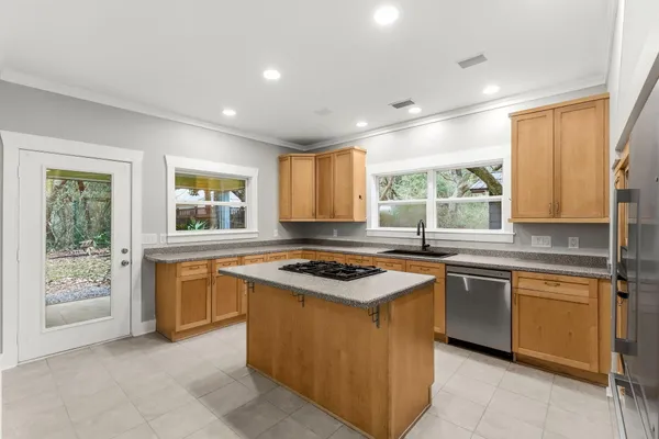 a kitchen with stainless steel appliances granite countertop stove top oven and cabinets