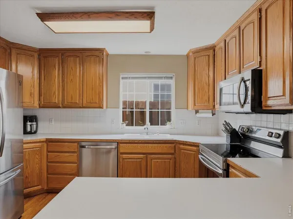 a kitchen with stainless steel appliances a sink stove and cabinets