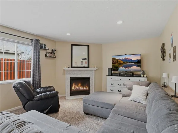 a living room with furniture a flat screen tv and a fireplace