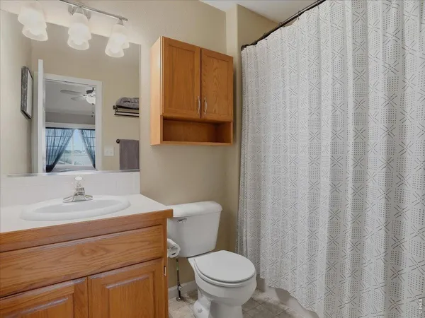 a bathroom with a sink a toilet and shower curtain