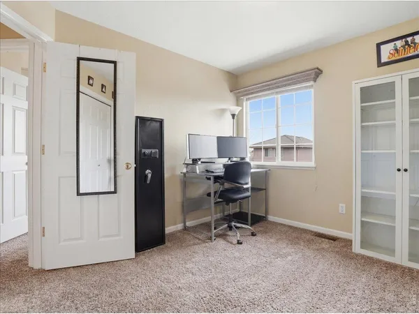 a view of a workspace with furniture and a window