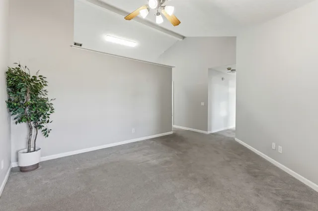 an empty room with potted plants in hallway