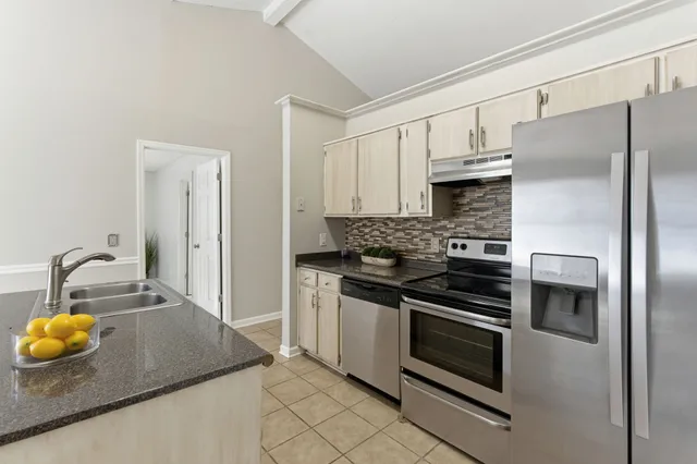 a kitchen with stainless steel appliances and granite countertop white cabinets