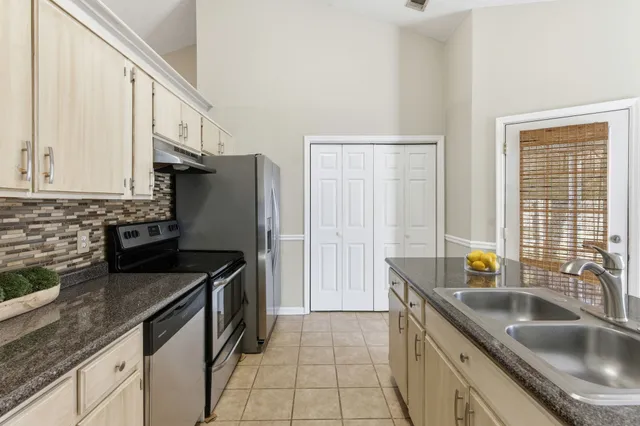 a kitchen that has a sink a stove and a refrigerator