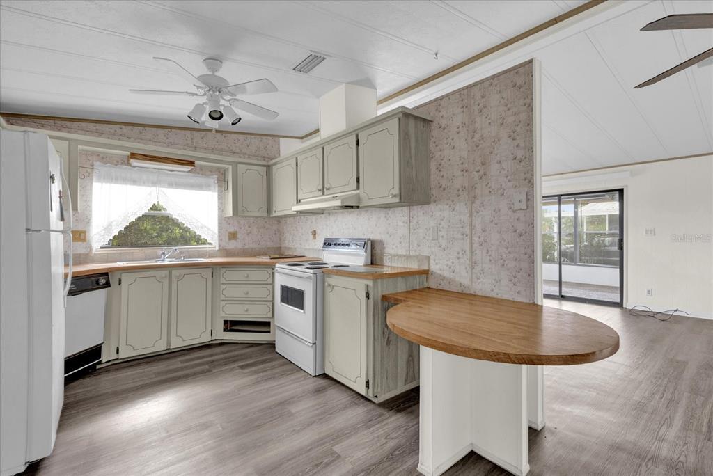 415 South Timber Trail Wildwood, FL 34785 - Photo 11 of 52 a kitchen with a table chairs sink and cabinets