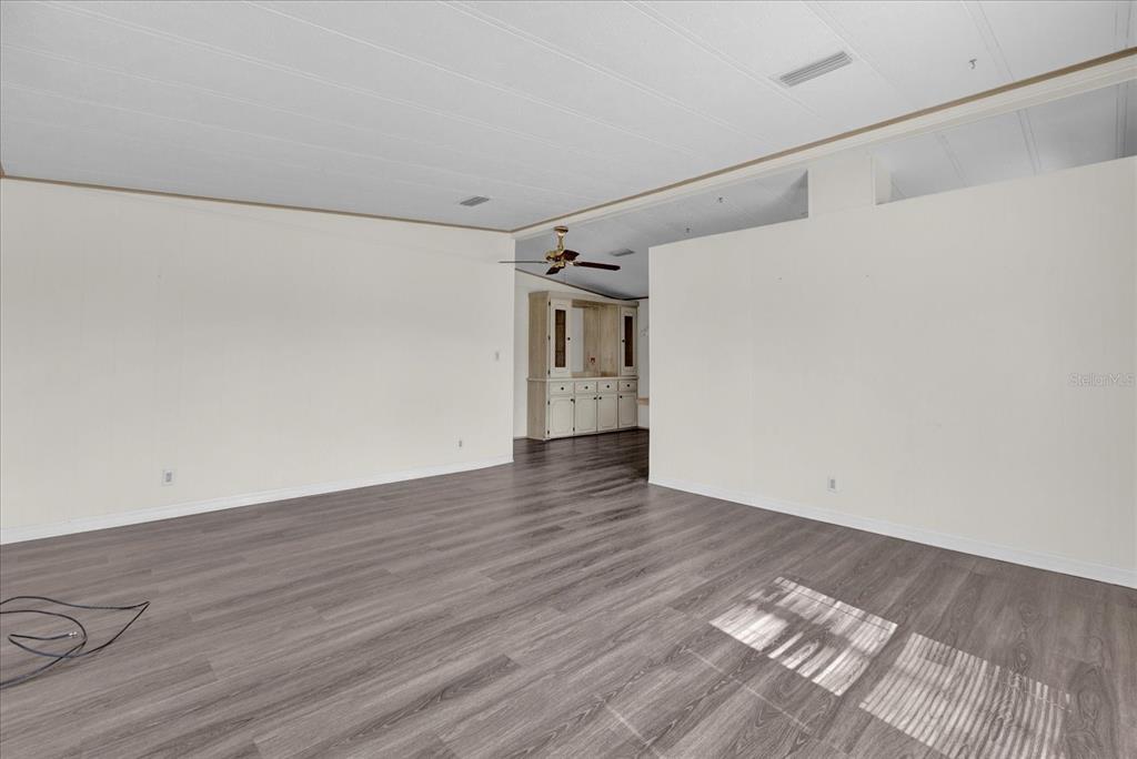 415 South Timber Trail Wildwood, FL 34785 - Photo 13 of 52 a view of empty room with wooden floor and fan