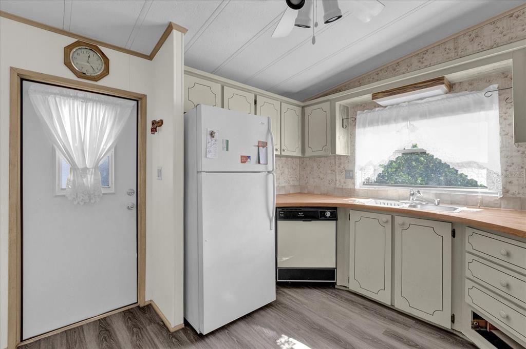 415 South Timber Trail Wildwood, FL 34785 - Photo 7 of 52 a kitchen with a refrigerator a sink and cabinets
