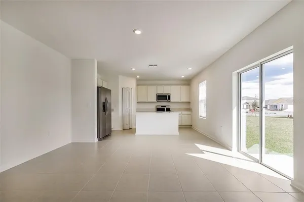 a view of kitchen with stainless steel appliances refrigerator oven and cabinets